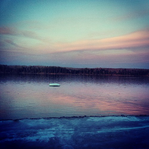 ice floe on a lake in Lac du Bonnet at a crepuscular time of day, with a pink and purple sky